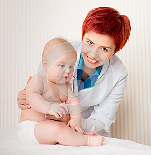 Smiling doctor with small baby