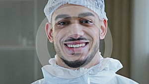 Smiling doctor arabic surgeon hispanic nurse medical worker in special uniform hat looks at camera smile toothy after photo