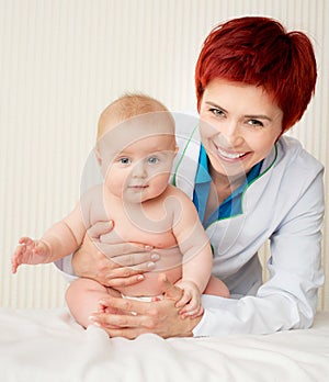 Smiling doctor with small baby