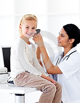 Smiling doctor checking her patient's ears