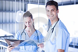 Smiling doctor examining a x ray report with his colleague