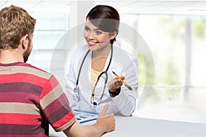 Smiling doctor giving a consultation to a patient in her medical