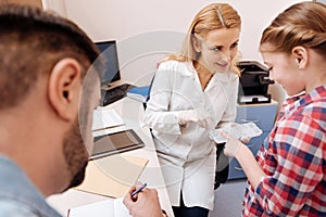 Smiling doctor giving holder for daily tablets