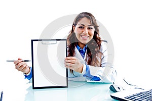 Smiling doctor indicating writing pad