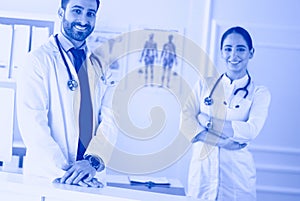 Smiling doctor man standing in front of his team and patient