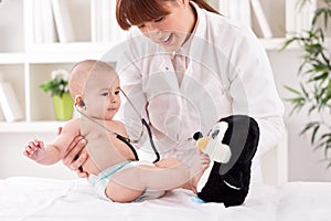 Smiling doctor pediatrician playing and enjoy with baby patient