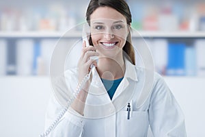 Smiling doctor phone calling