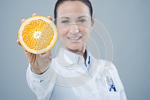 Smiling doctor showing a juicy orange