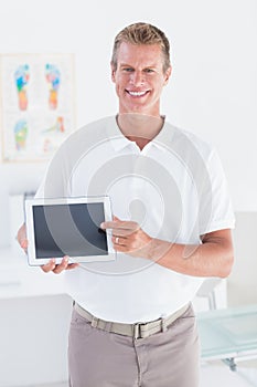 Smiling doctor showing laptop pc