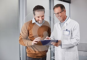 Smiling doctor showing man documents with recommendations