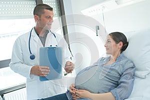 smiling doctor showing notes to patient