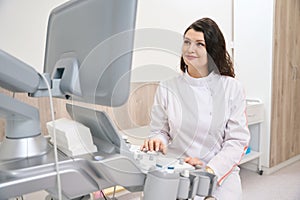 Smiling doctor sitting near the ultrasound scanner