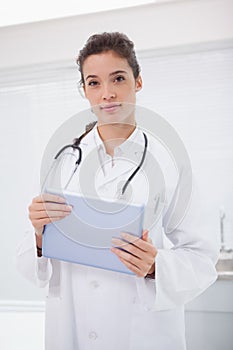Smiling doctor with stethoscope holding tablet pc