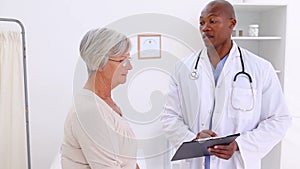 Smiling doctor talking with a mature woman