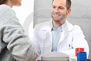Smiling doctor talking with a patient.
