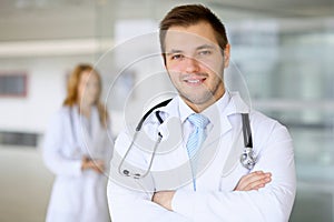 Smiling doctor waiting for his team while standing upright