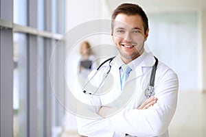 Smiling doctor waiting for his team while standing upright