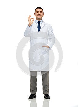 Smiling doctor in white coat showing ok hand sign