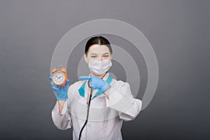 Smiling doctor woman pointing on clock, time to vaccine