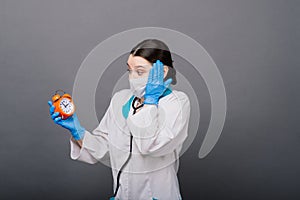 Smiling doctor woman pointing on clock, time to vaccine