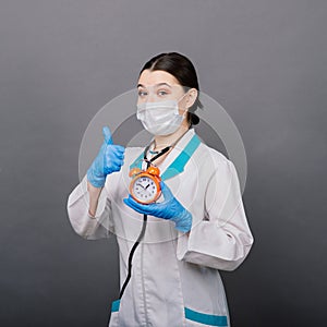 Smiling doctor woman pointing on clock, time to vaccine