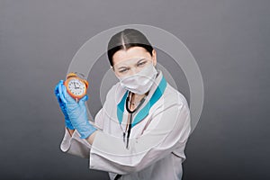 Smiling doctor woman pointing on clock, time to vaccine