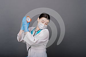 Smiling doctor woman pointing on clock, time to vaccine