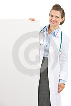 Smiling doctor woman showing blank billboard