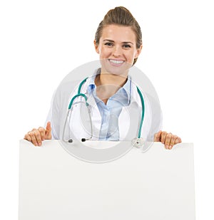 Smiling doctor woman showing blank billboard