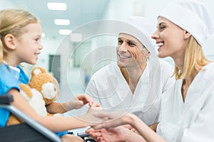 smiling doctors and patient on wheelchair