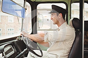 Smiling driver driving the school bus