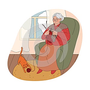 Smiling ederly woman grandmother sitting in armchair at home and knitting