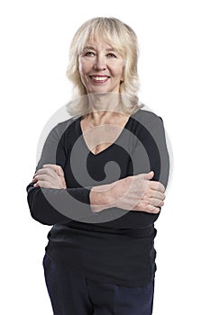 Smiling elderly blonde woman. A beautiful lady in a black sweater stands with her arms crossed over her chest. Activity, beauty