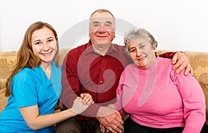 Smiling elderly couple and young caregiver