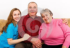 Smiling elderly couple and young caregiver