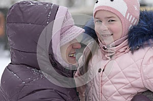 Smiling elderly lady hugged her granddaughter  in the winter