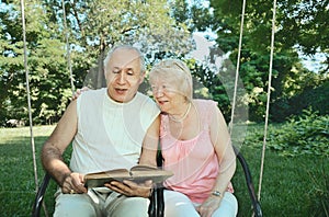 Smiling elderly man and woman 65-69 years old absorbedly readi