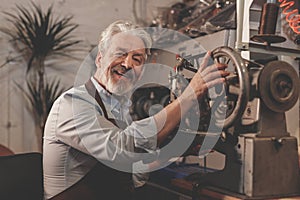 Smiling elderly man in a workshop