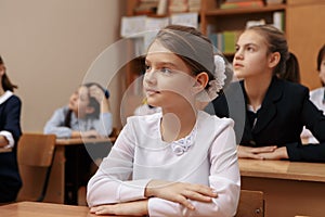 Smiling elderly teacher near the chalkboard asking student