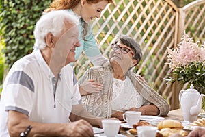 Smiling elderly woman and caregiver during meeting for lunch on