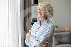 Smiling elderly woman look in distance feeling happy