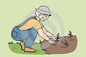 Smiling elderly woman plant seedlings