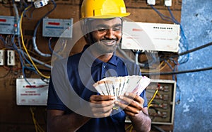 smiling electrician couting money - concept of payment after completion of work, successful career and happiness