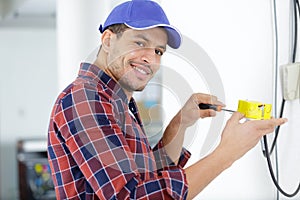 Smiling electrician wiring house photo