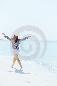 smiling elegant 40 years old woman on seacoast rejoicing