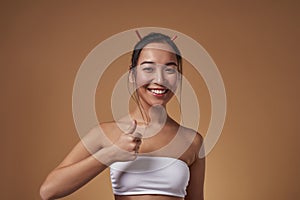 Smiling elegant asian girl show thumb up gesture