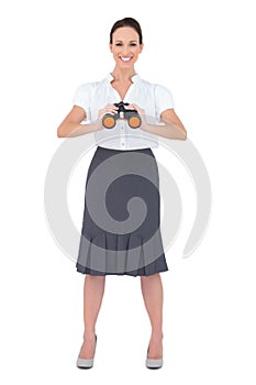 Smiling elegant businesswoman holding binoculars