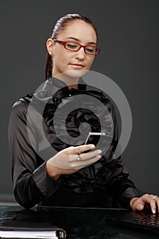 Smiling elegant businesswoman texting