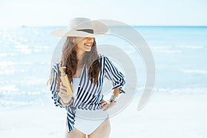 smiling elegant woman on beach with spf