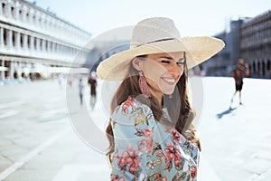 Smiling elegant woman in floral dress with hat photo